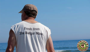 Badger Bill at the beach wearing a shirt that says Fresh from the Badger Mines